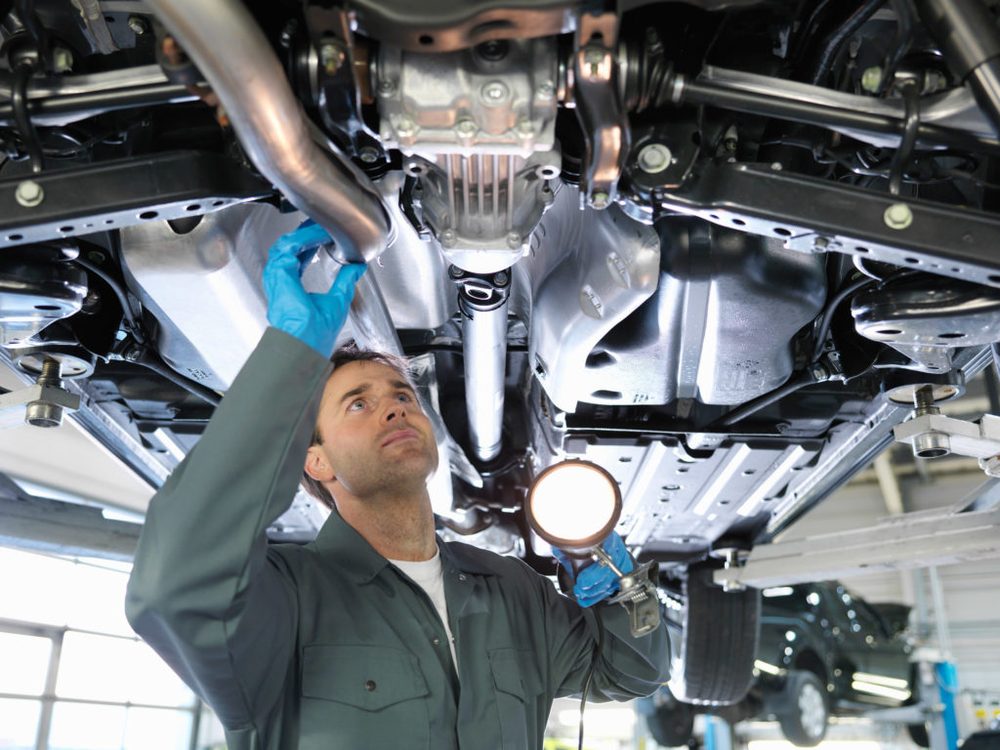 Technician working under a vehicle on a lift